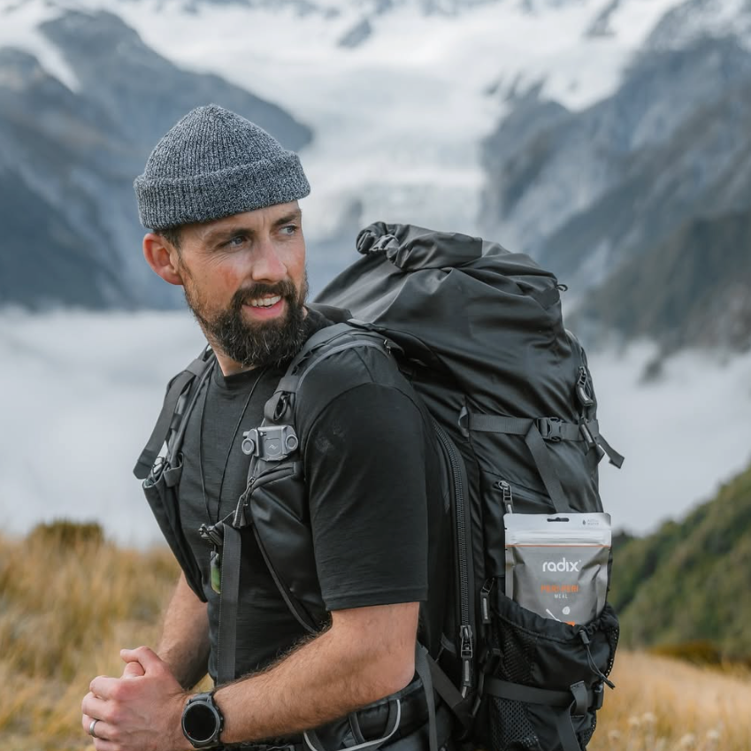Man with a backpack and hiking gear in a mountainous landscape