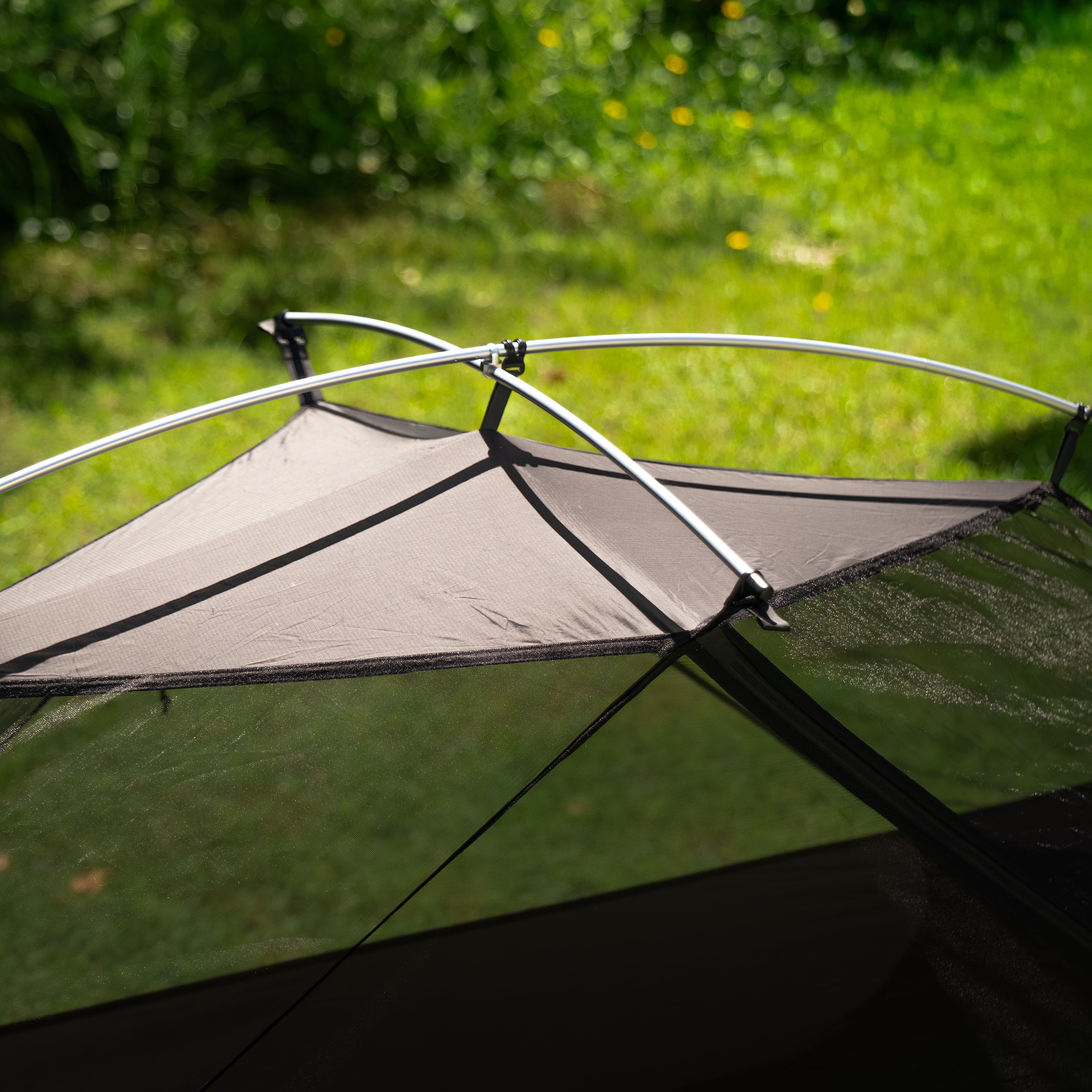 Camping tent with a rainfly on grass