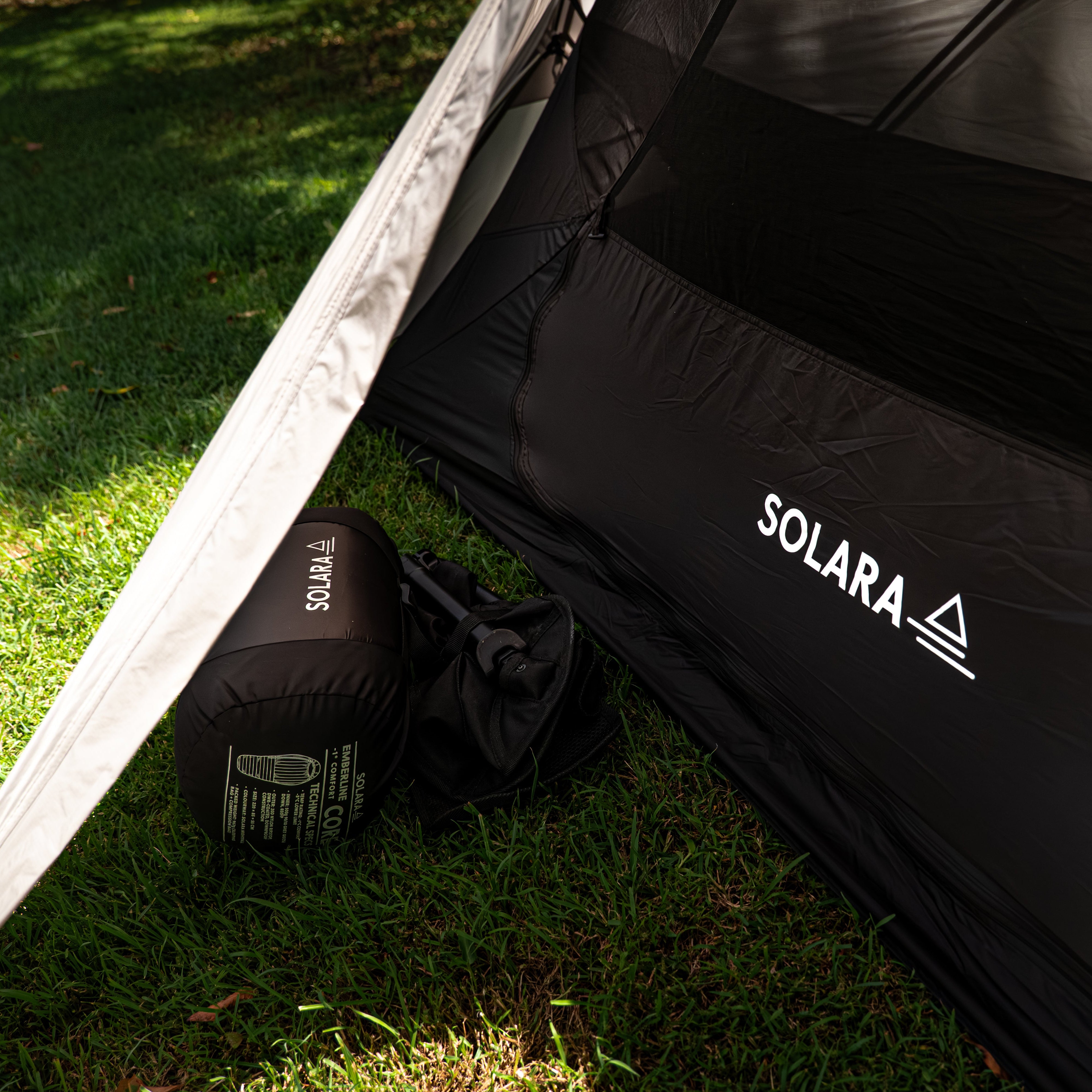 Black tent with 'SOLARA' branding on a grassy ground