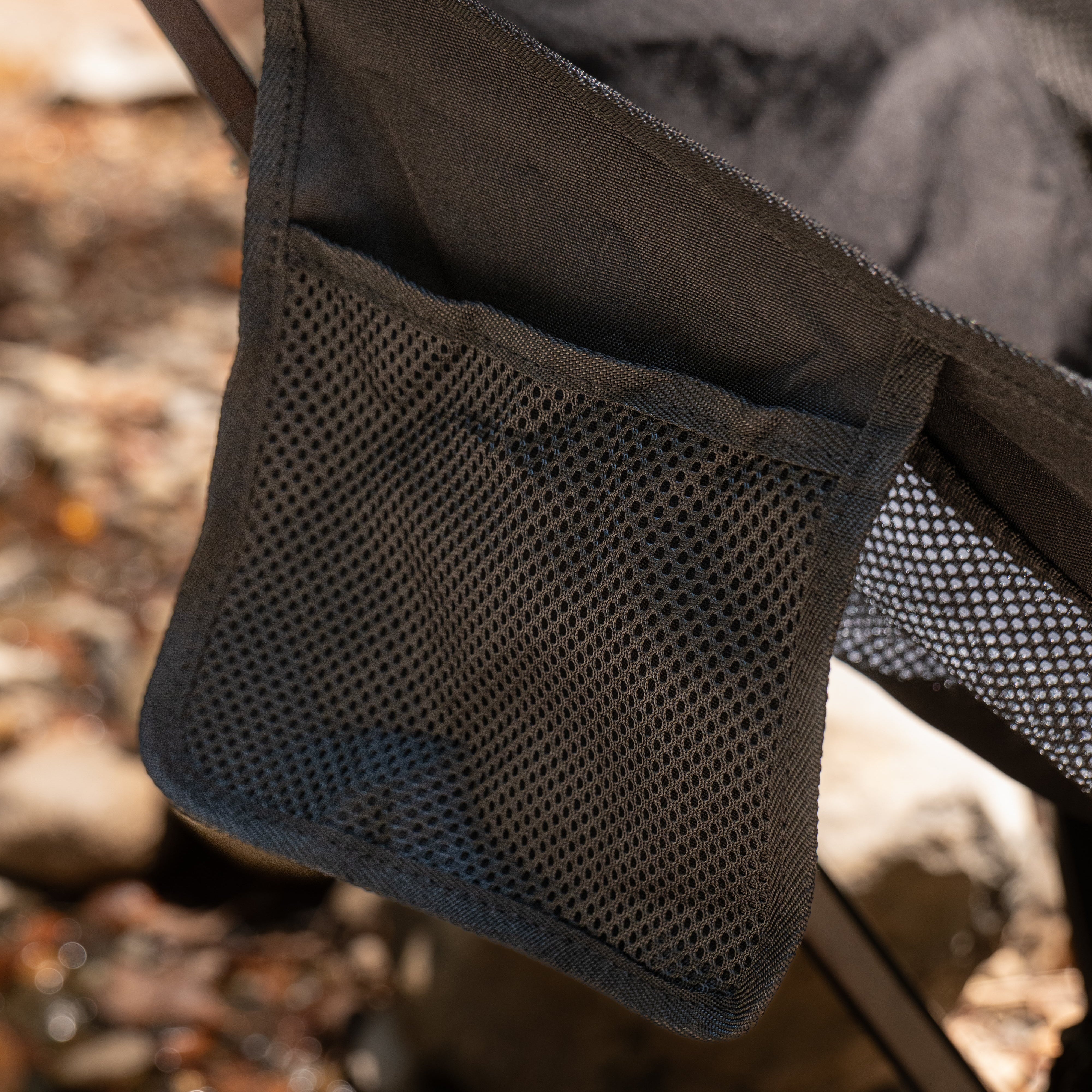 Close-up of a mesh pocket on a camping chair with a blurred natural background