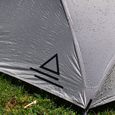 Close-up of a tent with raindrop patterns on the fabric, showing a brand logo.