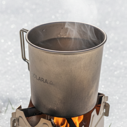 Portable stove with a pot on a snowy ground, featuring the Solara brand.
