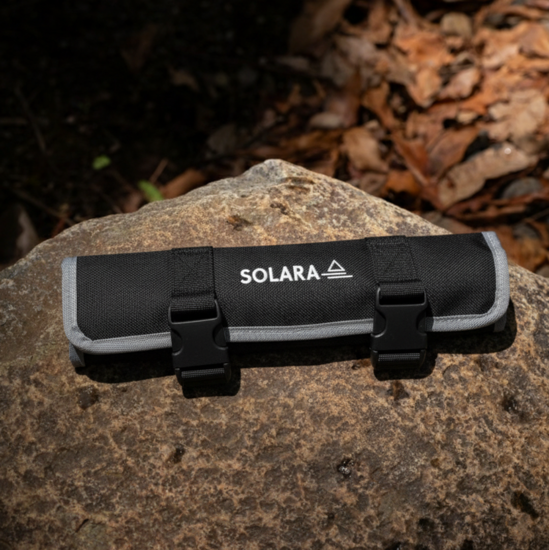 Black and gray tool roll with 'SOLARA' branding on a rock with leaves in the background